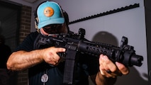 A photo of a man in a hallway holding an M4 rifle.