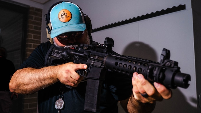 A photo of a man in a hallway holding an M4 rifle.