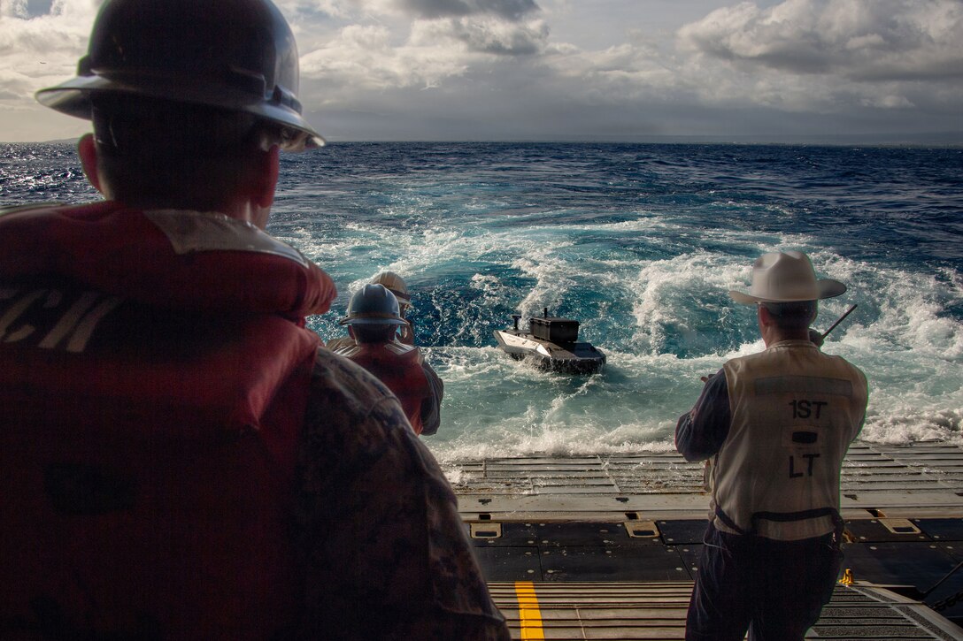 Digitally crewed surface vessel delivers parts for the 3D printer aboard Wasp-class amphibious assault ship USS Essex (LHD 2), during Rim of the Pacific (RIMPAC) 2026, July 7, 2026. Unmanned & remotely operated vessels extend the capability of interconnected manned platform sensors to enhance capacity across the multinational force. Thirty nations, over 30 surface ships, 5 submarines, 15 national land forces, more than 206 aircraft and 30,000 personnel are participating in RIMPAC in and around the Hawaiian Islands, June 24 to July 31. The world's largest international maritime exercise, RIMPAC provides a unique training opportunity while fostering and sustaining cooperative relationships among participants critical to ensuring the safety of sea lanes and security on the world's oceans. RIMPAC 2026 is the 30th exercise in the series that began in 1971. (U.S. Navy photo by Mass Communication Specialist Seaman Zachary Warr)