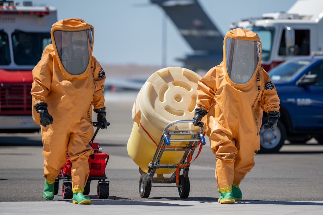 First responders transport hazardous material container.