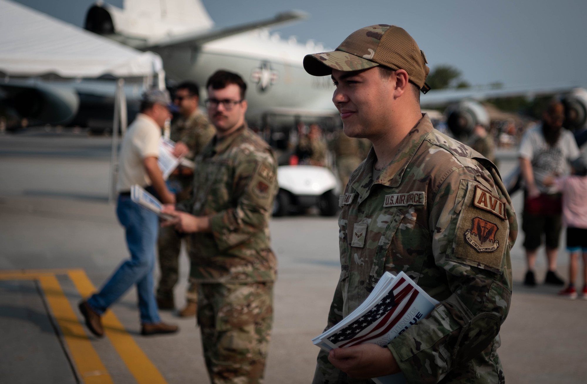 Airmen hold programs to give to local community members entering to attend the 2026 Defenders of Freedom Air & Space Show at Offutt Air Force Base, Nebraska, Aug. 8, 2026. The event highlighted the historic evolution of military aviation, bridging the gap between legacy heritage platforms and modern combat capabilities to preserve and share military history. (U.S. Air Force photo by Daniel Martinez)