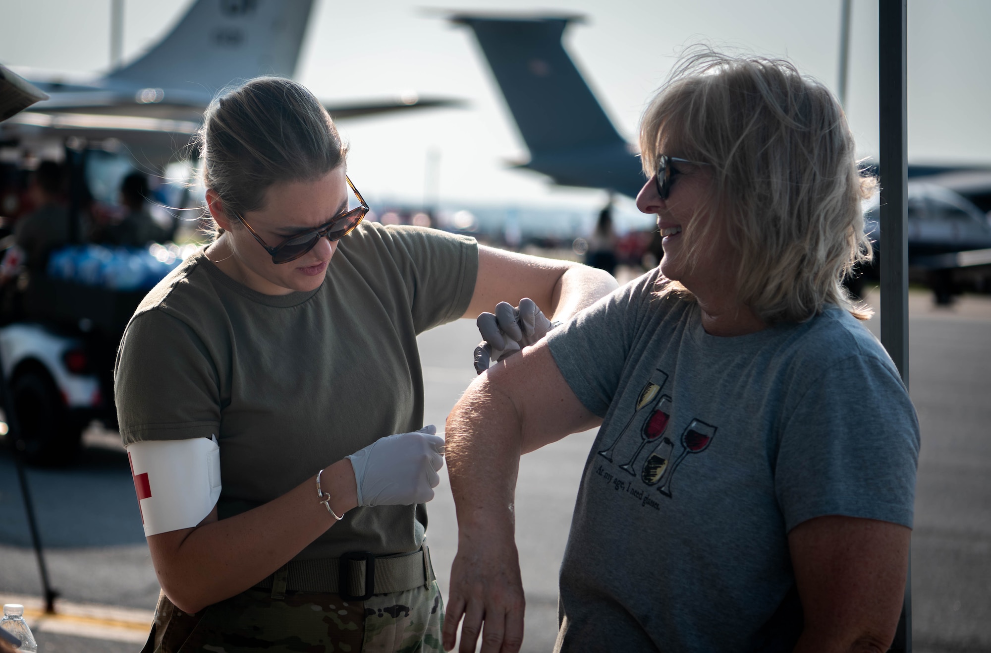 A U.S. Air Force medic applies a bandage to an attendee during the 2026 Defenders of Freedom Air & Space Show at Offutt Air Force Base, Nebraska, Aug. 9, 2026. The event served as a platform to celebrate Offutt AFB's military heritage, honoring the unique civilian-military bond with the Greater Omaha community that has supported the nation's defense for generations. (U.S. Air Force photo by Daniel Martinez)