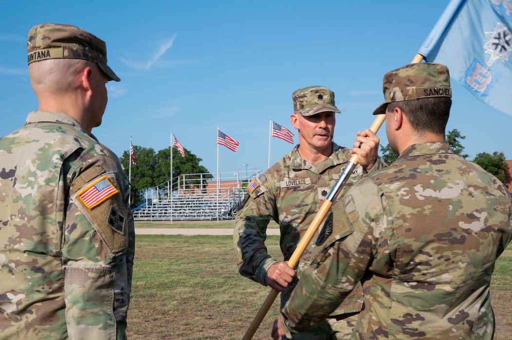 U.S. Army Lt. Col. Jonathan Lovelace, 344th Military Intelligence Battalion commander, passes the guidon to Capt. Andres Sanchez, incoming Bravo Company, 344th MI BN commander, during a change of command ceremony at Goodfellow Air Force Base, Texas, Aug. 7, 2026.