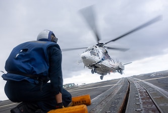 U.S. Navy Boatswain’s Mate Seaman Bar Htoo, from Texas, stands by with chocks and chains as an H225 Super Puma helicopter takes off from the flight deck aboard Arleigh Burke-class guided-missile destroyer USS Mustin (DDG 89) during flight operations while underway in the Indian Ocean, Aug. 11, 2026.