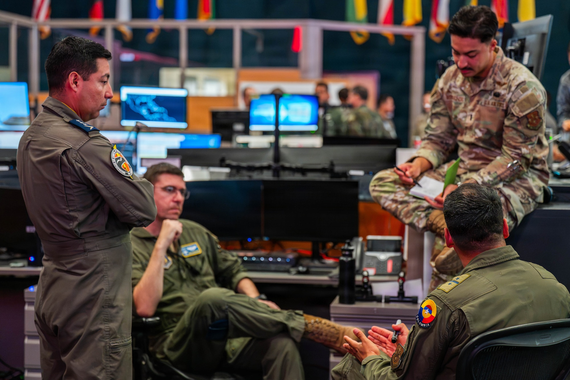 An Ecuadorian Air Force officer and a Colombian Aerospace Force officer discuss operational plans with U.S. Air Force officers participating in Exercise PANAMAX 2026 inside the Combined Air Operations Center at Davis-Monthan Air Force Base, Arizona, Aug. 6, 2026.