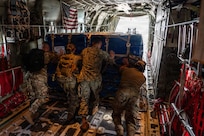 A group of people pushing cargo out of an aircraft