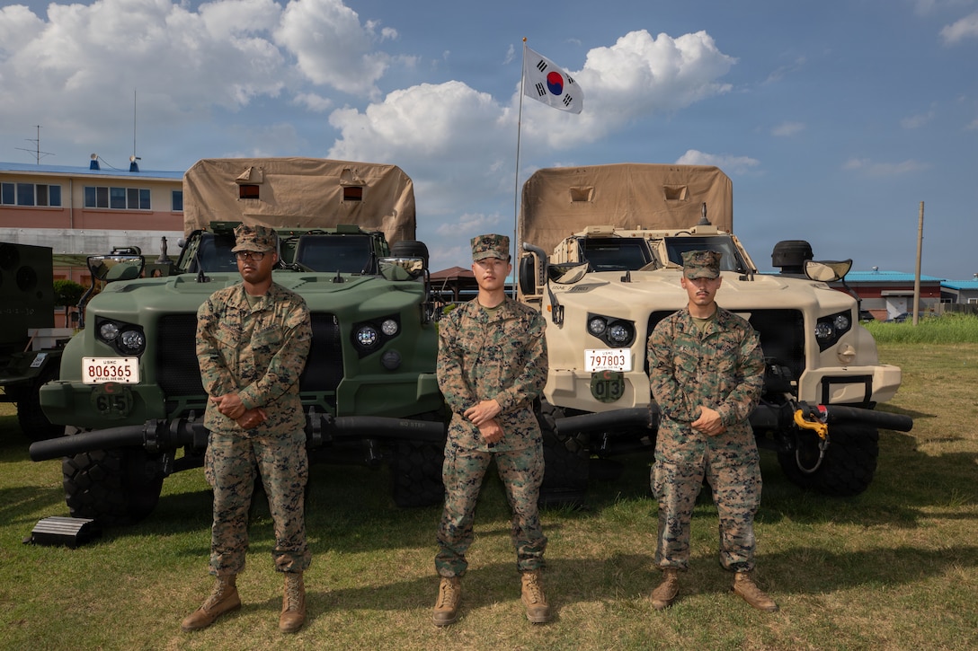 U.S. Marine Corps Lance Cpl. Min Suk Kim, center, an inventory management specialist, stands with Lance Cpl. Urayuan Pereiracruz, left, an electrician, and Cpl. Carlos Borba, a field radio operator, all with Marine Wing Support Squadron 171, Marine Aircraft Group 12, 1st Marine Aircraft Wing, during Combined Joint Logistics Over-the-Shore 26 in Pohang, South Korea, July 23, 2026. Kim supported communication between U.S. and Republic of Korea service members by providing interpretation. CJLOTS 26 is a combined exercise designed to integrate U.S. and Republic of Korea lighterage and ship-to-shore connector capabilities, improve combined readiness, strengthen the Republic of Korea-U.S. alliance, and expand combined maritime sustainment capacity during logistics operations. Kim is a native of Jeonju, South Korea; Pereiracruz is a native of Puerto Rico; Borba is a native of Washington. (U.S. Marine Corps photo by Lance Cpl. Marcus Henson)