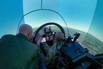 U.S. Air Force Maj. Gen. Roy Collins, Air Education and Training Command deputy commander, pilots a T-7A Red Hawk in the Ground Base Training System during his tour of the 12th Training Squadrons T-7A simulators at Joint Base San Antonio-Randolph, July 29, 2026. The visit allowed Collins to gain firsthand insight into how the T-7A Red Hawk GBTS will be used to prepare future Air Force pilots. During the tour, he learned how the integrated simulator and aircraft training environment will enhance undergraduate pilot training by providing students with realistic, high-fidelity instruction before they transition to flying the aircraft.