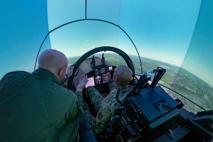 U.S. Air Force Maj. Gen. Roy Collins, Air Education and Training Command deputy commander, pilots a T-7A Red Hawk in the Ground Base Training System during his tour of the 12th Training Squadrons T-7A simulators at Joint Base San Antonio-Randolph, July 29, 2026. The visit allowed Collins to gain firsthand insight into how the T-7A Red Hawk GBTS will be used to prepare future Air Force pilots. During the tour, he learned how the integrated simulator and aircraft training environment will enhance undergraduate pilot training by providing students with realistic, high-fidelity instruction before they transition to flying the aircraft.