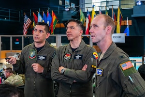 Colombian Aerospace Force Lt. Col. Juan Francisco Mora Moreno, left, provides an operational status update to Colombian Aerospace Force Col. Andrés Galvis Espejo, Deputy Combined Force Air Component Commander for PANAMAX 2026, center, and U.S. Air Force Col. Jonathan Grayson, 612th Air Operations Center commander, right, in the Combined Air Operations Center at Davis-Monthan Air Force Base, Arizona, Aug. 10, 2026.