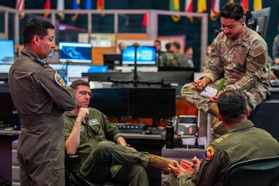 An Ecuadorian Air Force officer and a Colombian Aerospace Force officer discuss operational plans with U.S. Air Force officers participating in Exercise PANAMAX 2026 inside the Combined Air Operations Center at Davis-Monthan Air Force Base, Arizona, Aug. 6, 2026.