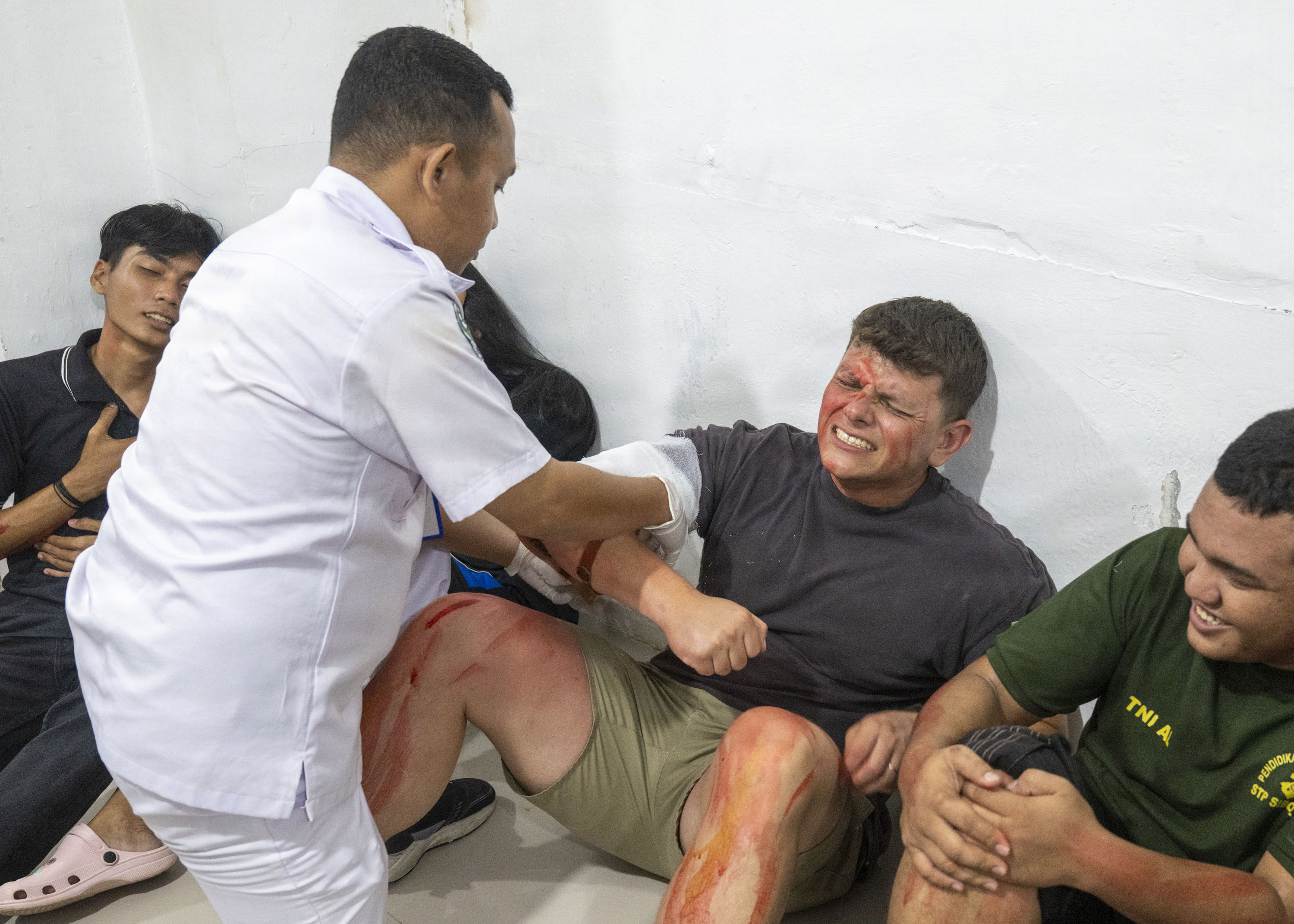 U.S. Army Reserve Staff Sgt. Kevin Hernandez, center-right, civil affairs team sergeant assigned to Pacific Partnership 2026 (PP26), acts as a simulated casualty during a two-day PP26 humanitarian assistance and disaster preparedness field training exercise at Rumah Sakit FL Tobing Sibolga hospital in Sibolga, Indonesia, July 28, 2026.