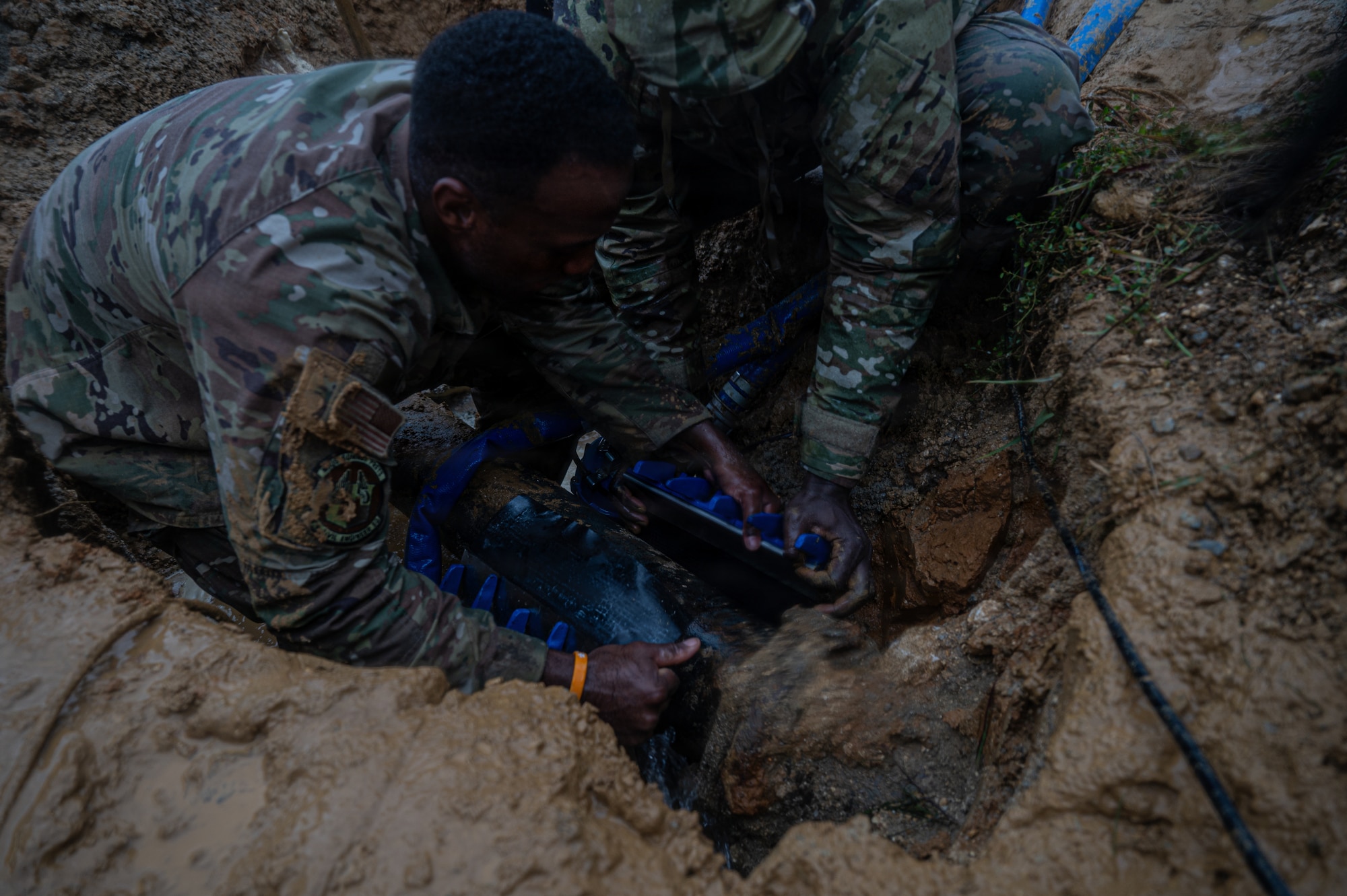 Airman installed a water line clamp on a ruptured pipe to restore water service.