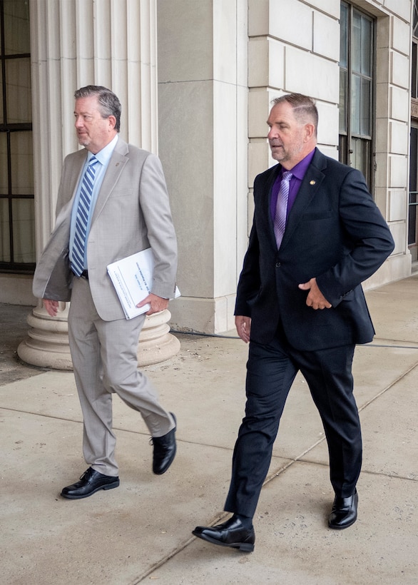 Defense Logistics Agency Vice Director Brad Bunn (left) and DLA Disposition Services Director Mike Cannon (right), converse as they approach an entrance to the Hart-Dole-Inouye Federal Center in Battle Creek, Michigan on August 11, 2026.