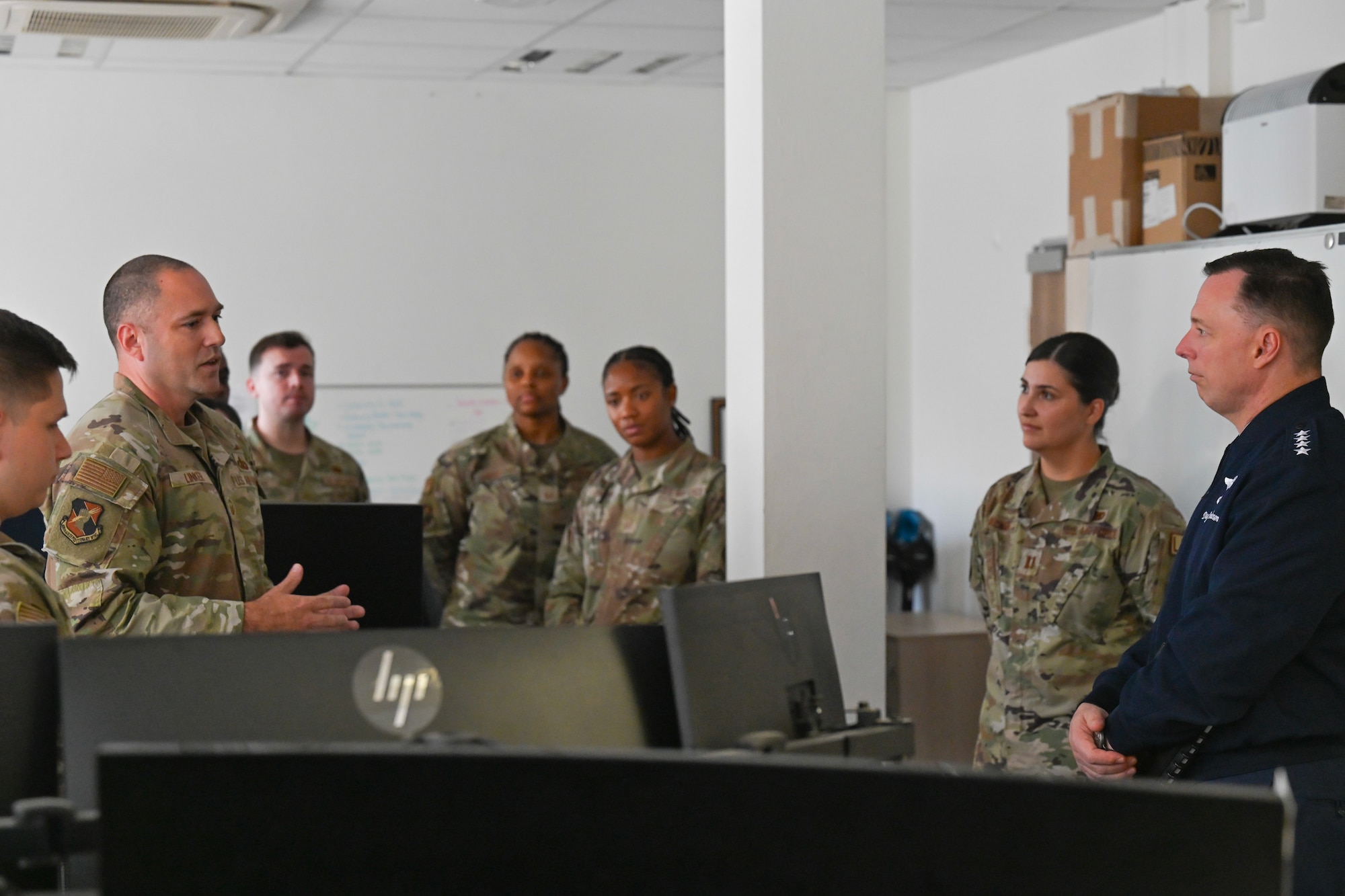 U.S. Air Force Gen. Dagvin Anderson, commander, U.S. Africa Command, right, listens to U.S. Air Force Senior Master Sgt. Gregory Linker, 406th Air Expeditionary Wing Manpower, Personnel, and Services director, far left, during an immersion at Ramstein Air Base, Germany, August 10, 2026. The 406th AEW provided Anderson an immersion and overview of their role as the only U.S. Air Force wing on the African continent and how they support combatant command objectives. (U.S. Air Force photo by Capt. Benjamin Aronson)