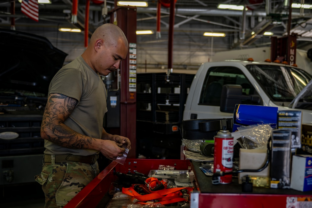 Vehicle maintenance airman sorting through tools before working on vehicle