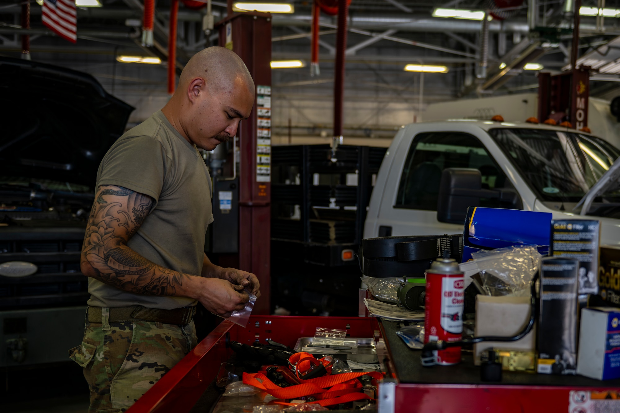 Vehicle maintenance airman sorting through tools before working on vehicle