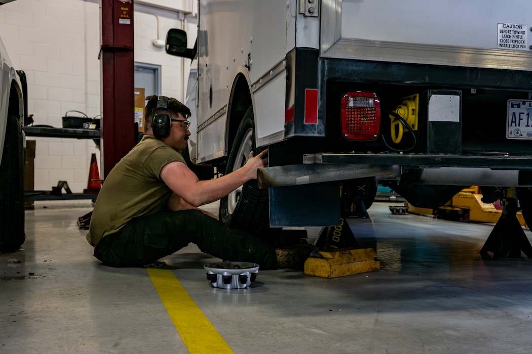 Vehicle maintenance airman changing a tire on a vehicle