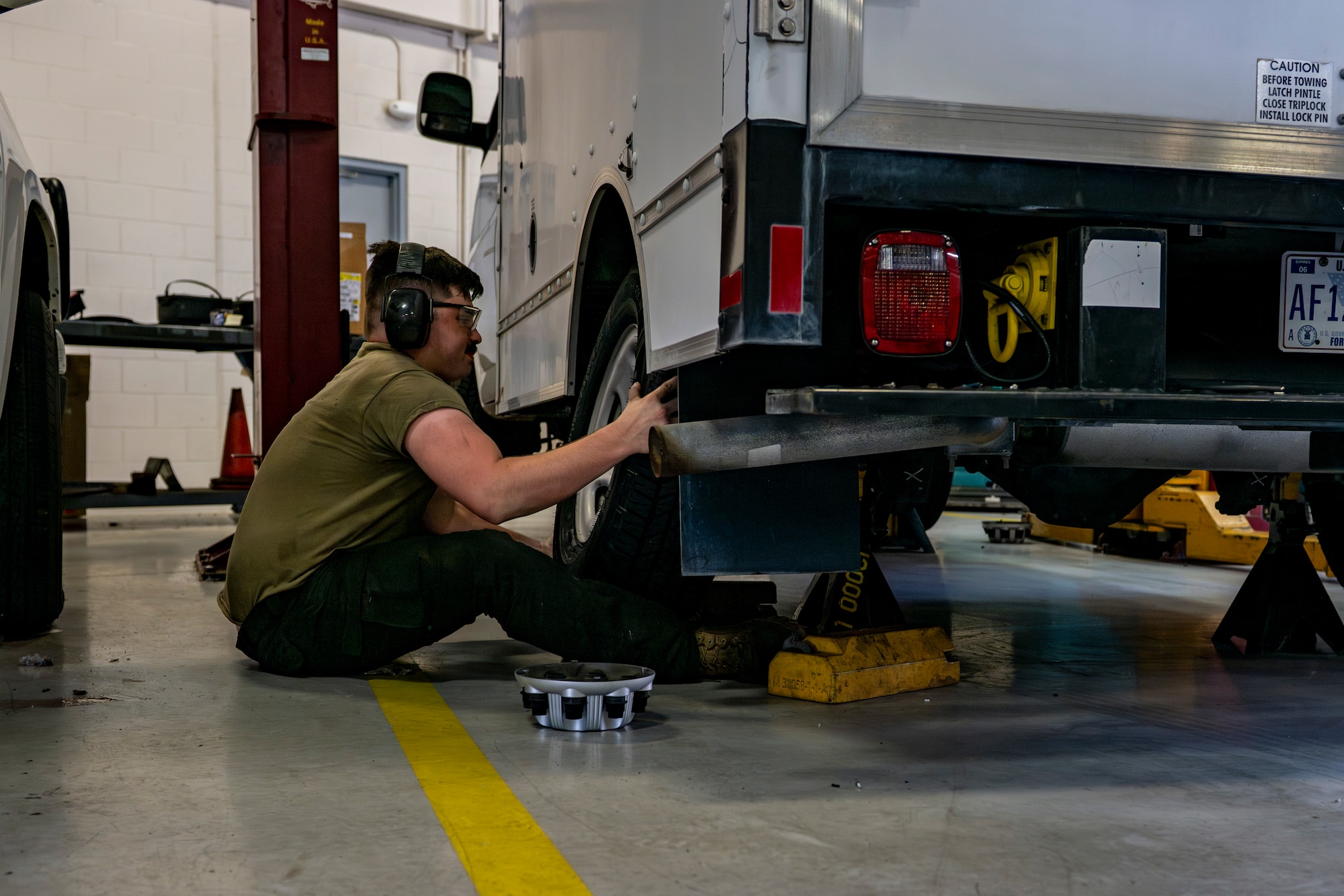 Vehicle maintenance airman changing a tire on a vehicle