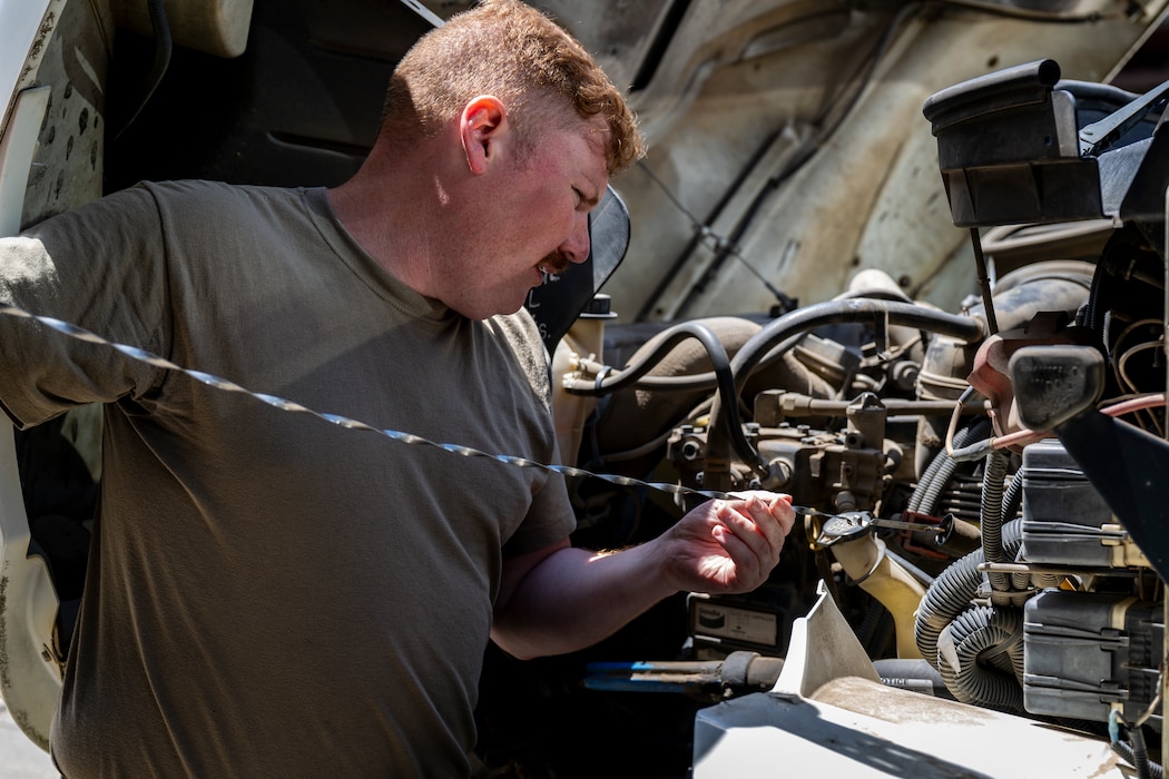 Vehicle Maintenance airman checking the oil of a vehicle