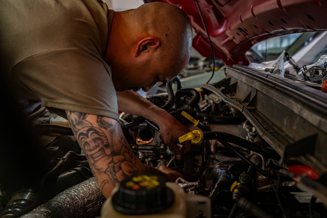 Airman in vehicle maintenance working on a vehicle engine