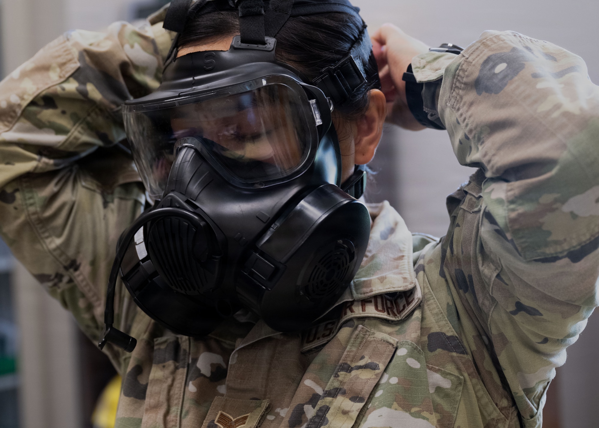U.S. Air Force Senior Airman Gillian Dacsig, 6th Operational Medical Readiness Squadron bioenvironmental engineering technician, dons a gas mask during a fit test at MacDill Air Force Base, Florida, Aug. 3, 2026. Gas masks play a vital role in protecting service members during chemical, biological, radiological and nuclear attacks in contested environments. (U.S. Air Force photo by Senior Airman Nelvis Sera)