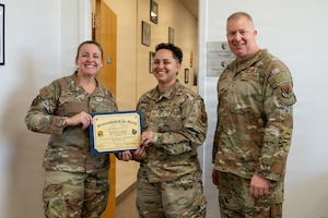 Col. Christine Littlejohn, Chief Master Sgt. Scott Castrovinci, and Tech. Sgt. Sarah Gonzales pose for a photo.