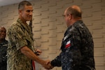 Rear Adm. Carlos Sardiello, commander, U.S. Naval Forces Southern Command/U.S. 4th Fleet, gives Chilean Navy Capt. Juan Pablo Villanueva an award at the final ceremony of exercise Panamax 2026. PANAMAX is a U.S. Southern Command-sponsored exercise focused on strengthening hemispheric command and control and enhancing regional cooperation to secure the Western Hemisphere. (U.S. Navy photo by Mass Communication Specialist Third Class David Keenan)