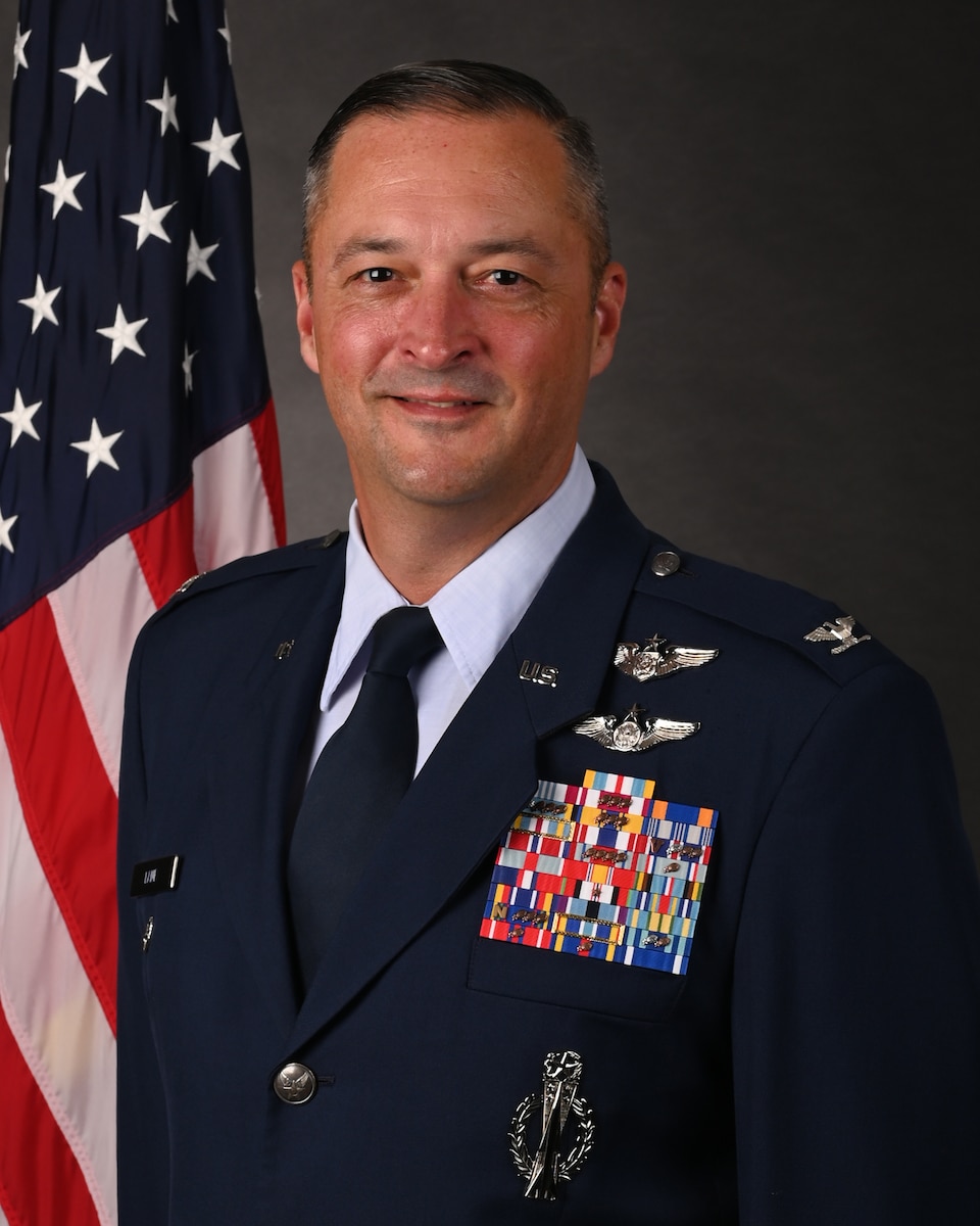 Photo of Colonel Brian B. Lane standing in front of an American Flag