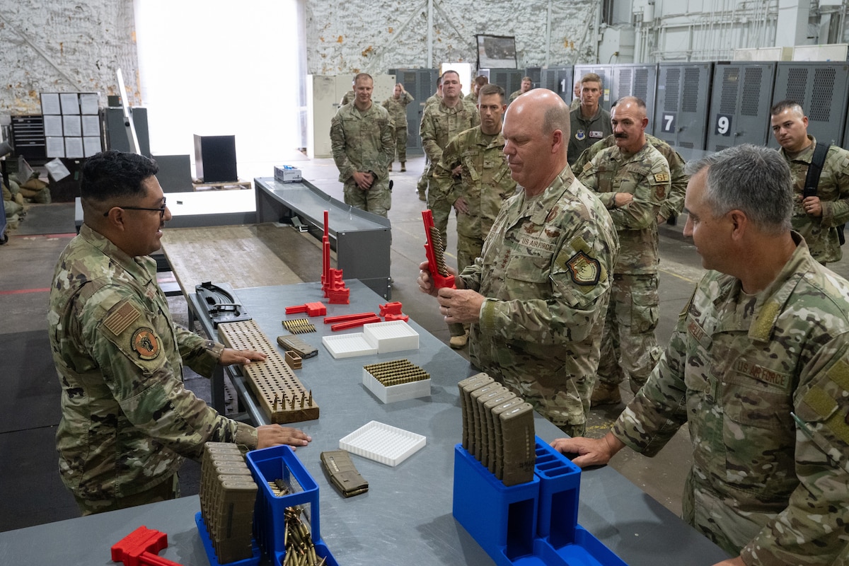U.S. Air Force Tech. Sgt. Kelvin Moreno, 91st Missile Wing Atomic Spark innovation co-director, shows Gen. S.L. Davis, commander of Air Force Global Strike Command, and Chief Master Sgt. Shawn M. Aiello, command chief of AFGSC, a 3D-printed firearm magazine loader during a visit at Minot Air Force Base, North Dakota, July 30, 2026.