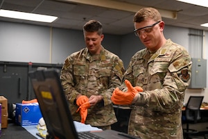 Chief Master Sgt. Joshua Moore, 1st Special Operations Wing command chief, left, and Col. Mark Hamilton, 1st SOW commander, don protective gear during a leadership immersion at Hurlburt Field, Florida, July 24, 2026.