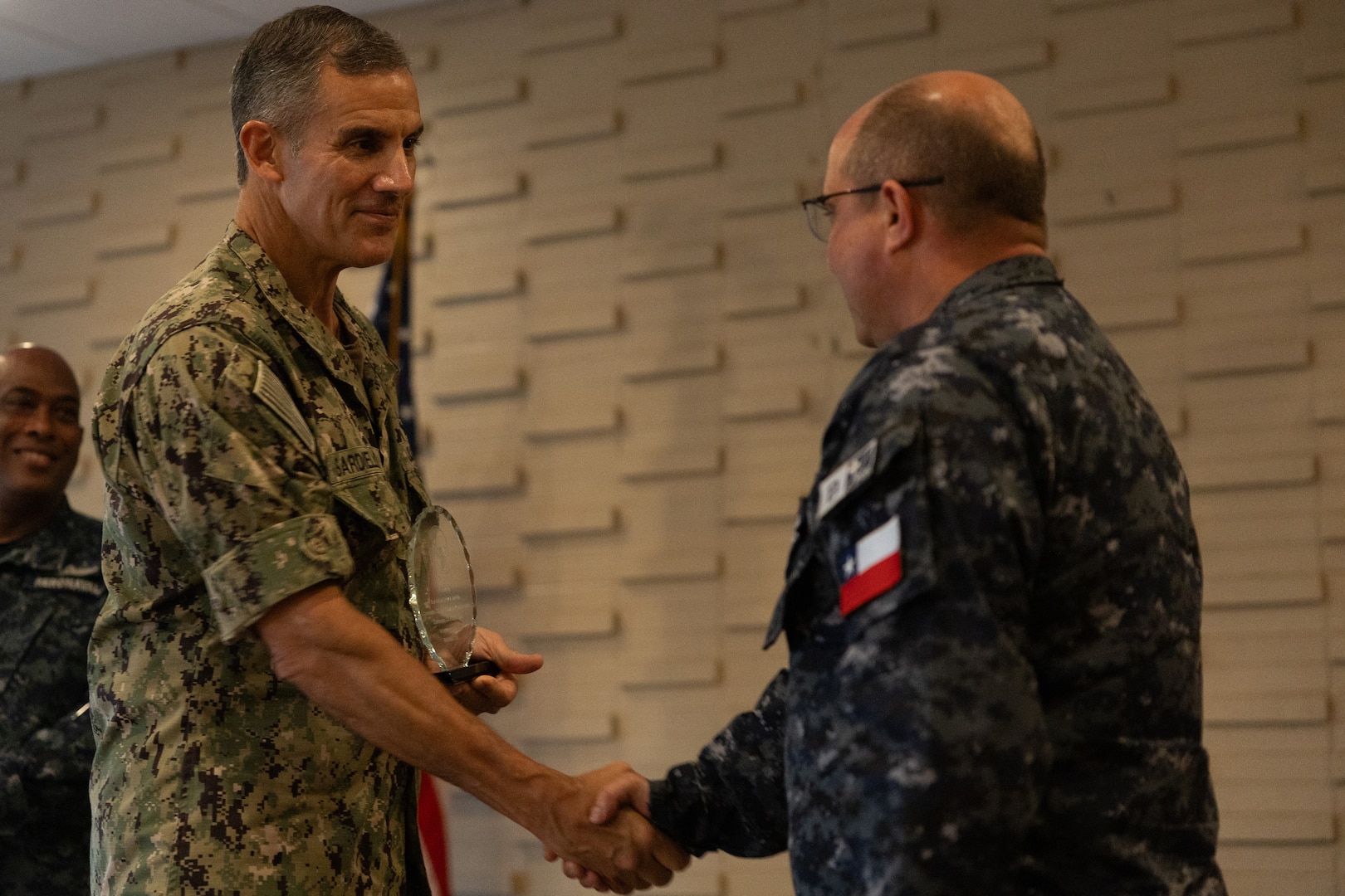 Rear Adm. Carlos Sardiello, commander, U.S. Naval Forces Southern Command/U.S. 4th Fleet, gives Chilean Navy Capt. Juan Pablo Villanueva an award at the final ceremony of exercise Panamax 2026. PANAMAX is a U.S. Southern Command-sponsored exercise focused on strengthening hemispheric command and control and enhancing regional cooperation to secure the Western Hemisphere. (U.S. Navy photo by Mass Communication Specialist Third Class David Keenan)