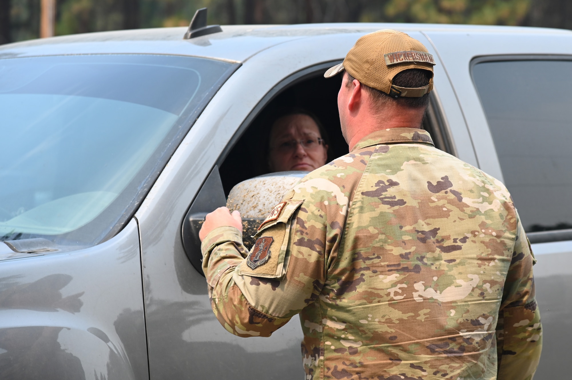 uniformed member speaks to a civilian in there vehicle