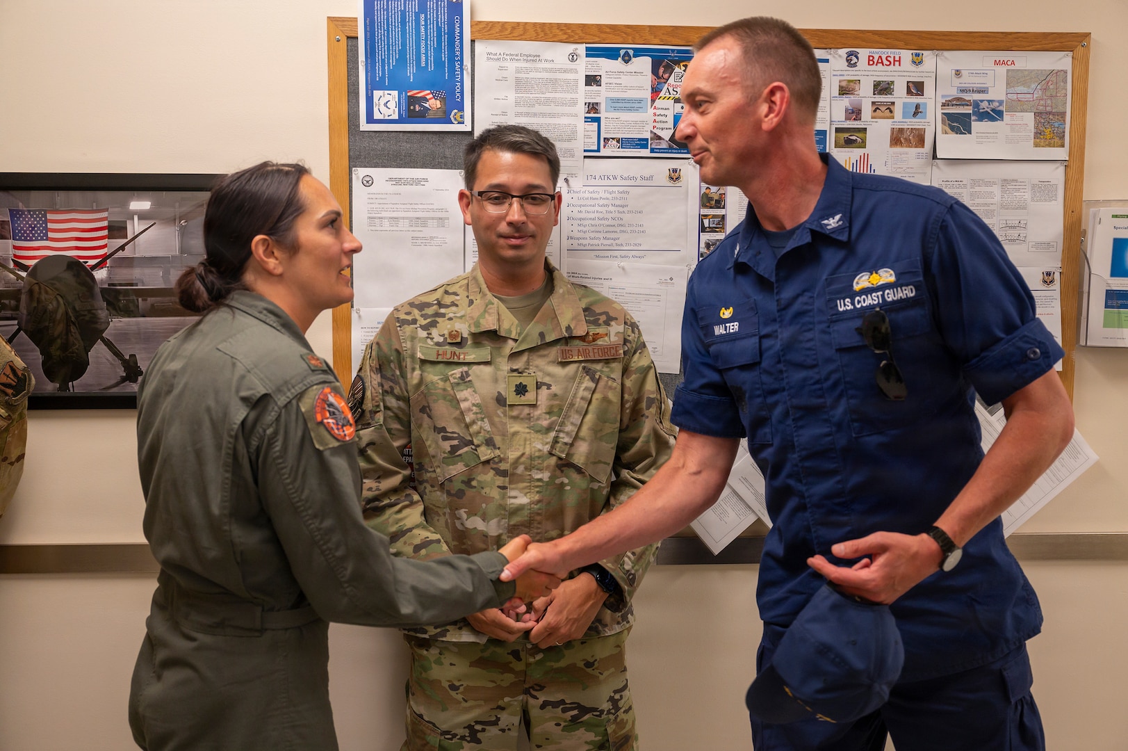 U.S. Air Force Maj. Nicole Clay, left, a MQ-9 Reaper pilot assigned to the 174th Attack Wing, accepts a commander's coin from U.S. Coast Guard Capt. Matthew Walter, commander of U.S. Coast Guard Sector Eastern Great Lakes, at Hancock Field Air National Guard Base, Syracuse, New York, July 13, 2026.