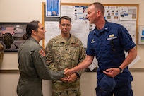 U.S. Air Force Maj. Nicole Clay, left, a MQ-9 Reaper pilot assigned to the 174th Attack Wing, accepts a commander's coin from U.S. Coast Guard Capt. Matthew Walter, commander of U.S. Coast Guard Sector Eastern Great Lakes, at Hancock Field Air National Guard Base, Syracuse, New York, July 13, 2026.