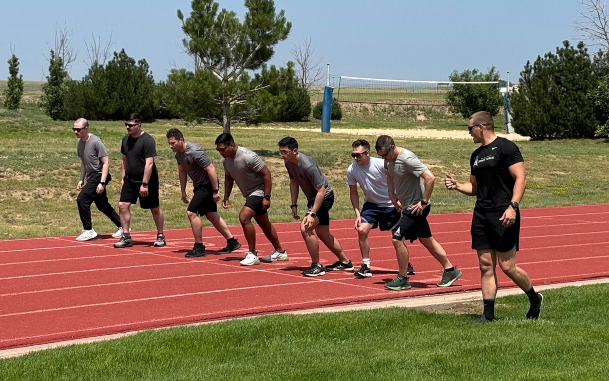 Service Members preparing to run on a track on Schriever Space Force Base, Colorado.