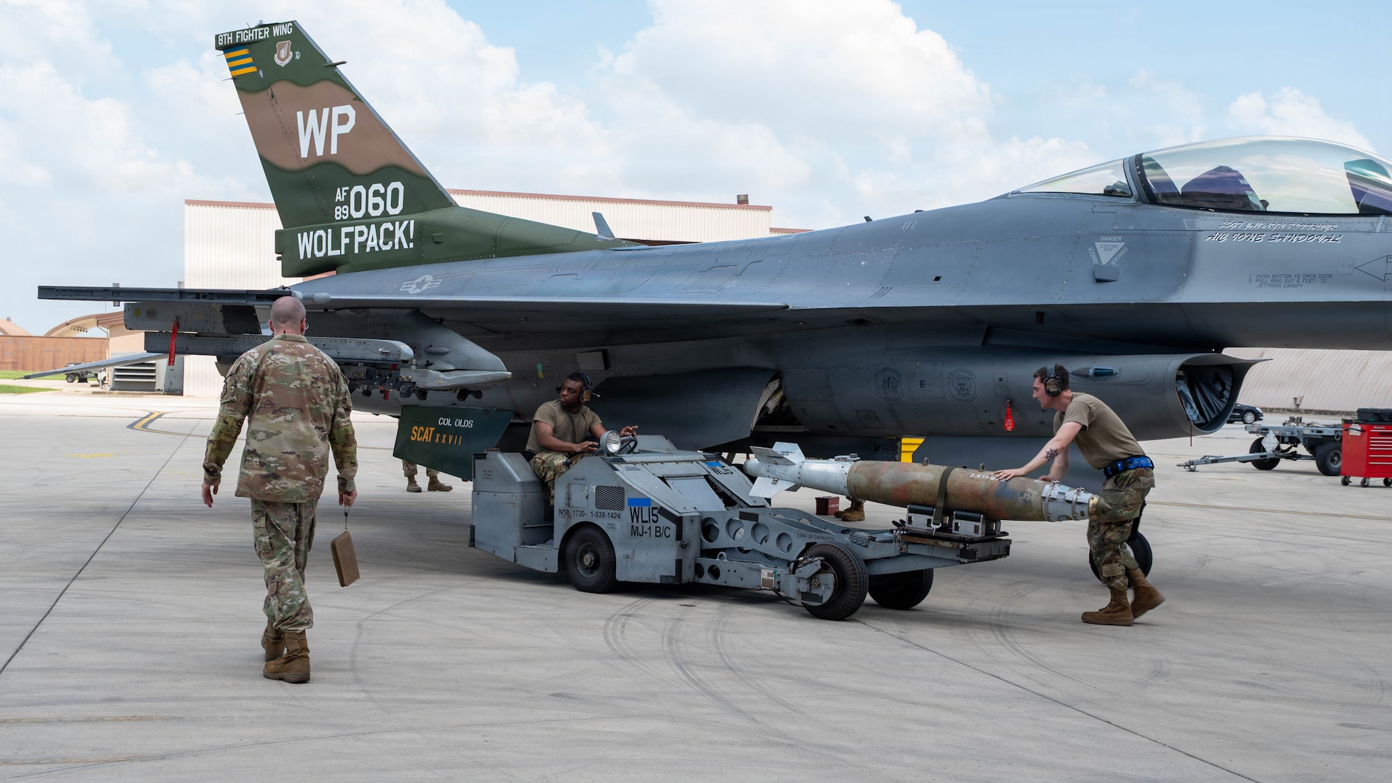 U.S. Air Force Staff Sgt. Kevin Jones, center, and Staff Sgt. Thomas Clark, right, assigned to the 51st Aircraft Maintenance Squadron weapons load crew members, transports a GBU-38 during the second-quarter Ammo Bomb Building and Loading Competition at Osan Air Base, Republic of Korea, Aug. 6, 2026. The competition involved loading munitions onto F-16 Fighting Falcons in timed environments, simulating the urgency of real-world combat operations. (U.S. Air Force photo by Senior Airman Jessica Mun)