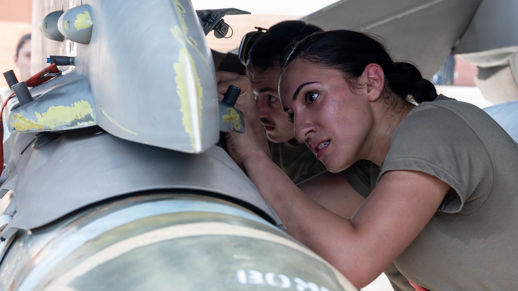U.S. Air Force Airman 1st Class Skye Vargas, foreground, and Staff Sgt. Jordan Davis, 36th Fighter Generation Squadron weapons load crew members, tighten bolts during the second-quarter Ammo Bomb Building and Loading Competition at Osan Air Base, Republic of Korea, Aug. 6, 2026. The competition tested weapons load crews on technical accuracy, adherence to safety protocols, team coordination and loading time as they loaded munitions onto F-16 Fighting Falcons. (U.S. Air Force photo by Senior Airman Jessica Mun)