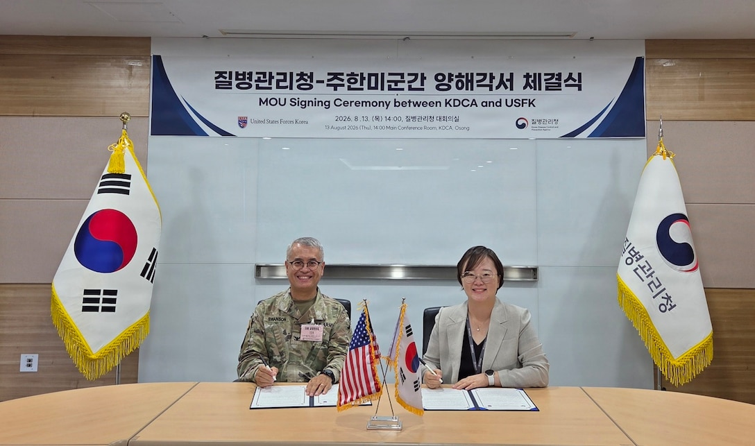 Col. Eric Swanson and a Korea Disease Control and Prevention Agency official sit at a table signing a Memorandum of Understanding during the 2026 SOFA Subcommittee on Disease Prevention and Control in Osong.