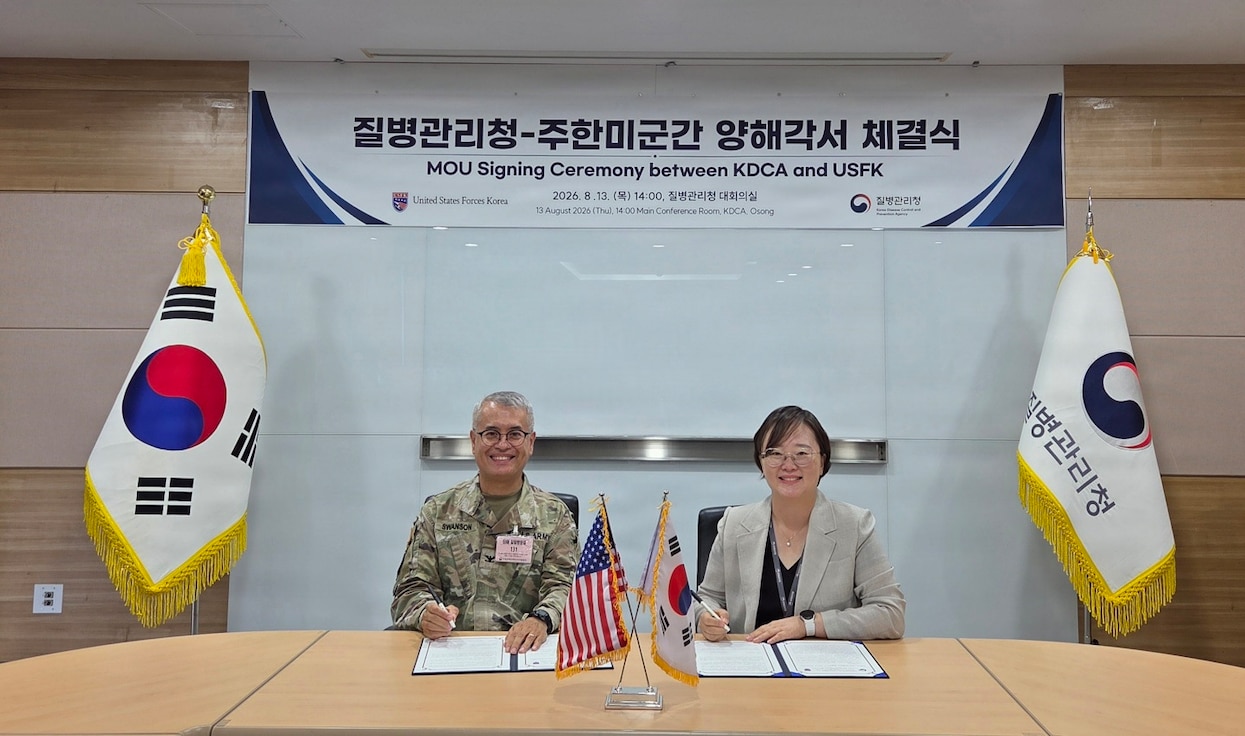 Col. Eric Swanson and a Korea Disease Control and Prevention Agency official sit at a table signing a Memorandum of Understanding during the 2026 SOFA Subcommittee on Disease Prevention and Control in Osong.