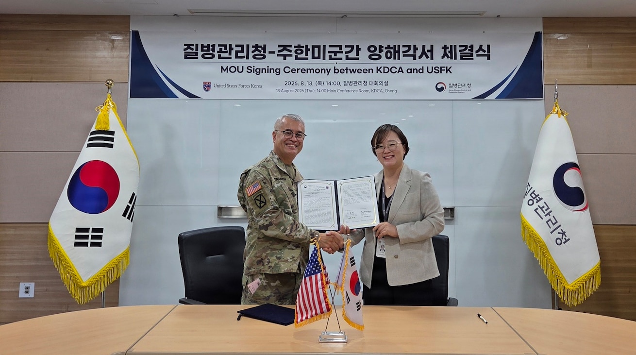 Col. Eric Swanson and a Korea Disease Control and Prevention Agency official sit at a table signing a Memorandum of Understanding during the 2026 SOFA Subcommittee on Disease Prevention and Control in Osong.