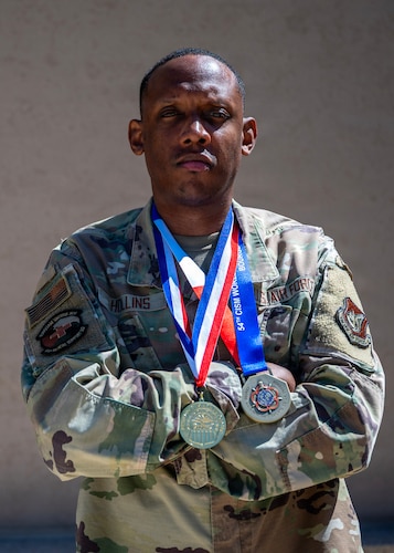 U.S. Air Force Master Sgt. Marcus Hollins, 51st Medical Support Squadron pharmacy operations section chief, poses with Air Force Women’s Basketball medals at Osan Air Base, Republic of Korea, Aug. 12, 2026. Hollins began coaching early on at the high school level before rising to the opportunity to coach the U.S. Air Force Women’s Basketball Team. (U.S. Air Force photo by Staff Sgt. Sarah Williams)
