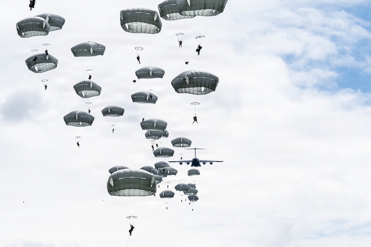 U.S. Army paratroopers assigned to the 1st Battalion, 511th Parachute Infantry Regiment, 11th Airborne Division, jump from a U.S. Air Force C-17 Globemaster III over Joint Base Elmendorf-Richardson, Alaska, July 15, 2026, during exercise Arctic Predictable Iron 26. The five-day exercise included rapid-movement training and airdrop operations. (U.S. Air Force photo by Senior Airman Lauren Torres)