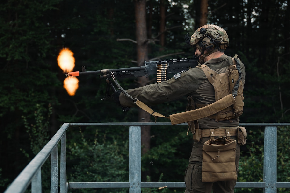 U.S. Air Force Staff Sgt. Kane Dew, 569th U.S. Forces Police Squadron lead training instructor, fires an M240B machine gun at simulated hostile forces during a field training exercise at Kapaun Air Station, Germany, July 23, 2026. The exercise strengthened shoot-and-move techniques, communication, land navigation, mounted operations and combat-response skills to support evolving mission requirements. (U.S. Air Force photo by Airman 1st Class Paden Lancaster)