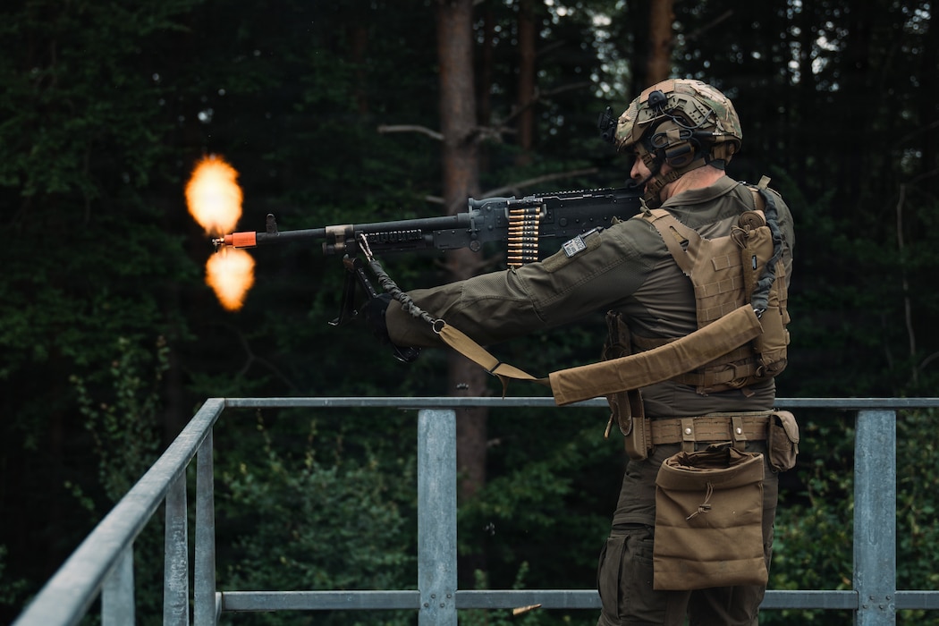 U.S. Air Force Staff Sgt. Kane Dew, 569th U.S. Forces Police Squadron lead training instructor, fires an M240B machine gun at simulated hostile forces during a field training exercise at Kapaun Air Station, Germany, July 23, 2026. The exercise strengthened shoot-and-move techniques, communication, land navigation, mounted operations and combat-response skills to support evolving mission requirements. (U.S. Air Force photo by Airman 1st Class Paden Lancaster)