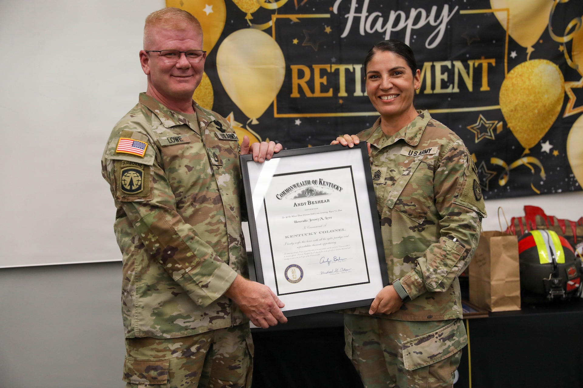 U.S. Army Sgt. Maj. Naarah Stallard, Kentucky Army National Guard G3 sergeant major, presents Sgt. 1st Class Jeremy Lowe with the Kentucky Colonel commissioning certificate from the Governor during his retirement ceremony July 29, 2026.