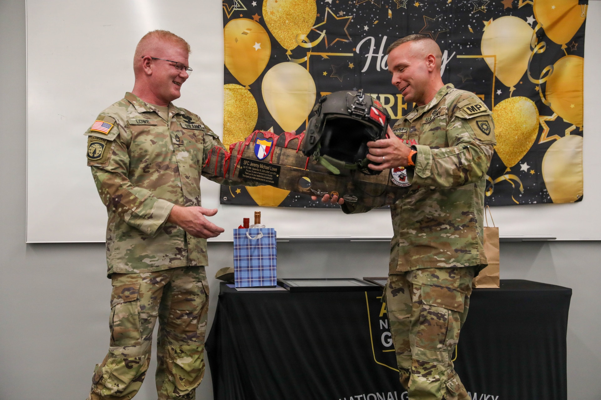 U.S. Army 1st Sgt. Fred Ulshafer, G3 plans and operations noncommissioned officer, presents Sgt. 1st Class Jeremy Lowe with a unique gift of appreciation during his retirement ceremony, July 29, 2026.