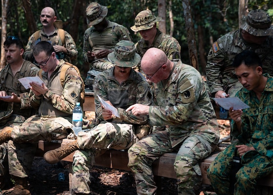 U.S. Army Col. Michael Scanlon, deputy chief of staff for operations, Oklahoma Army National Guard and Soldiers from 1st Squadron, 180th Cavalry Regiment, 45th Infantry Brigade Combat Team work to plot a grid coordinate during jungle land navigation training at Tutong Camp, Brunei Darussalam, Aug. 12, 2026. Oklahoma Army National Guard Soldiers with 1st Squadron, 180th Regiment, 45th Infantry Brigade Combat Team worked alongside 3rd Platoon, Alpha Company, 2nd Battalion, RBLF to develop land navigation skills in a jungle environment as part of Exercise Pahlawan Warrior 26. Exercise Pahlawan Warrior is a biennial bilateral exercise between the U.S. Army Pacific and the RBLF, designed to enhance readiness, interoperability, and strengthen bilateral defense cooperation. (Oklahoma National Guard photo by Sgt. Danielle Rayon)