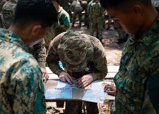 U.S. Army and RBLF personnel work together to plot a grid coordinate on a map during jungle land navigation training at Tutong Camp, Brunei Darussalam, Aug. 12, 2026. Oklahoma Army National Guard Soldiers with 1st Squadron, 180th Regiment, 45th Infantry Brigade Combat Team worked alongside 3rd Platoon, Alpha Company, 2nd Battalion, RBLF to develop land navigation skills in a jungle environment as part of Exercise Pahlawan Warrior 26. Exercise Pahlawan Warrior is a biennial bilateral exercise between the U.S. Army Pacific and the RBLF, designed to enhance readiness, interoperability, and strengthen bilateral defense cooperation. (Oklahoma National Guard photo by Sgt. Danielle Rayon)