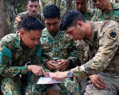U.S. Army and Royal Brunei Land Force (RBLF) Soldiers work together to plot a grid coordinate on a map during jungle land navigation training at Tutong Camp, Brunei Darussalam, Aug. 12, 2026. Oklahoma Army National Guard Soldiers with 1st Squadron, 180th Regiment, 45th Infantry Brigade Combat Team worked alongside 3rd Platoon, Alpha Company, 2nd Battalion, RBLF to develop land navigation skills in a jungle environment as part of Exercise Pahlawan Warrior 26. Exercise Pahlawan Warrior is a biennial bilateral exercise between the U.S. Army Pacific and the RBLF, designed to enhance readiness, interoperability, and strengthen bilateral defense cooperation. (Oklahoma National Guard photo by Sgt. Danielle Rayon)